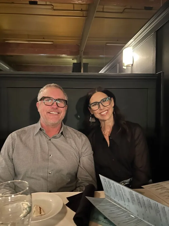 A couple at dinner, the man wearing LOOK OPTIC Cosmo readers