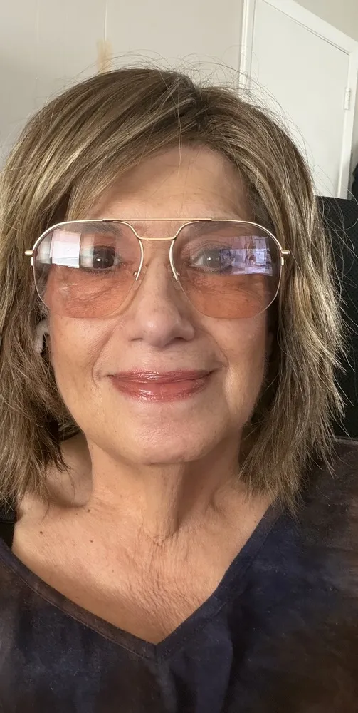 Andrea wearing LOOK OPTIC Muse frames with gold rims and rose-tinted lenses