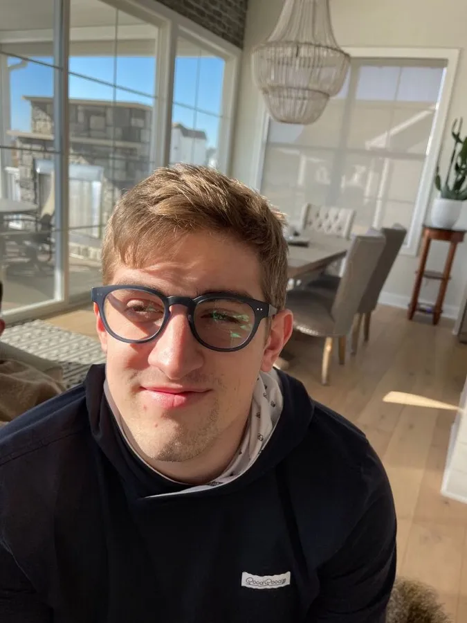 A young man studying in LOOK OPTIC Abbey blue light glasses in navy