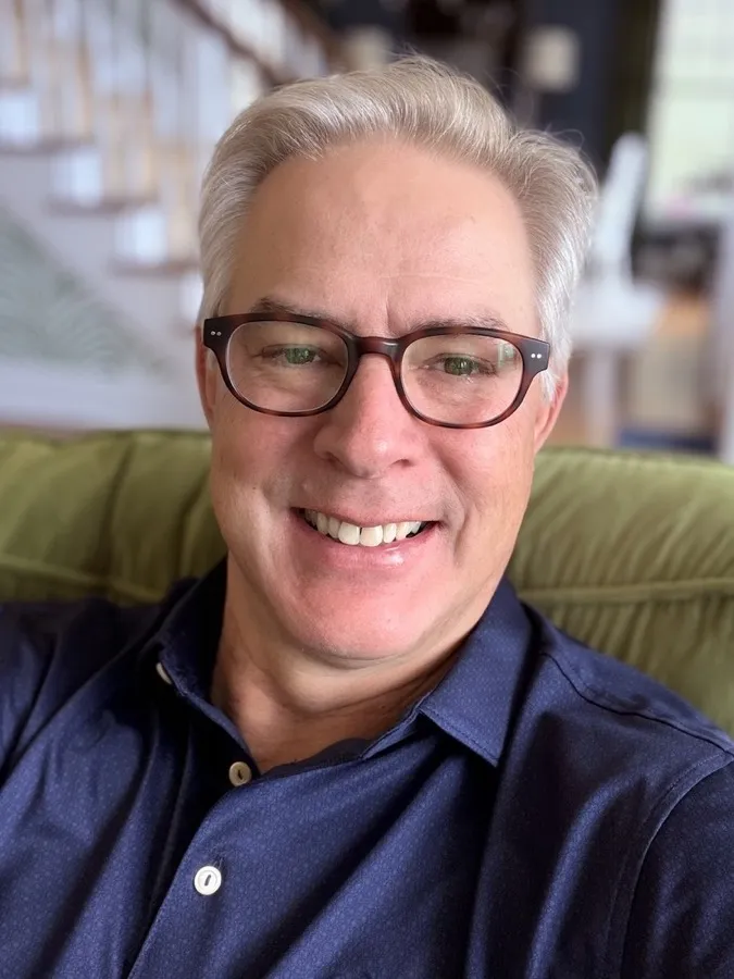Kenneth smiling in LOOK OPTIC Sullivan progressives, silver hair, navy shirt