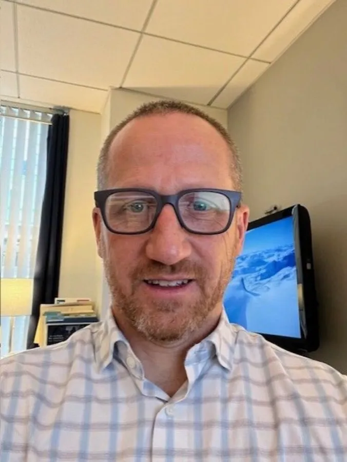 Kevin smiling in LOOK OPTIC Cosmo-Medium progressives at his office desk