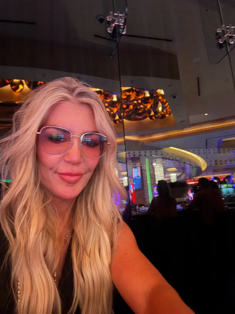 Kim wearing LOOK OPTIC Gina frames with tinted lenses at a restaurant