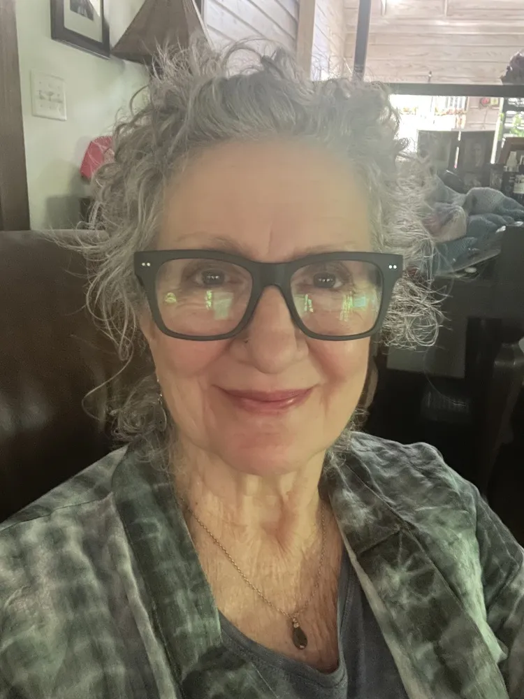 Mitzi wearing LOOK OPTIC Cosmo Progressives with amber-tinted lenses, indoors